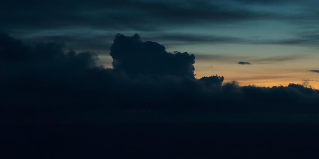 Broken cloud layers over a dark sea at dusk with amber light in the gaps